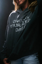 Person wearing blue hoodie with white 'crucify your flesh daily' text on a dark background