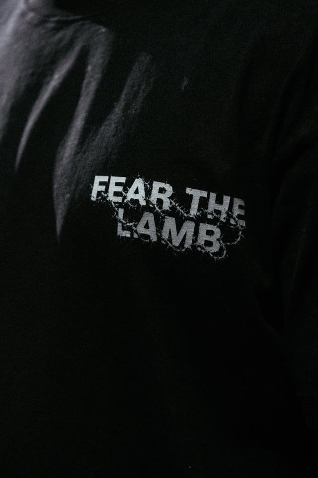 Black shirt with 'FEAR THE LAMB' text on a dark background
